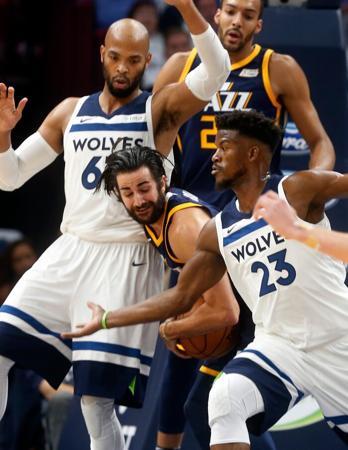 Utah Jazz's Ricky Rubio, center, of Spain, drives between Minnesota Timberwolves' Taj Gibson, left, and Jimmy Butler during the first half of an NBA basketball game Friday, Oct. 20, 2017, in Minneapolis. AP Photo/Jim Mone)
