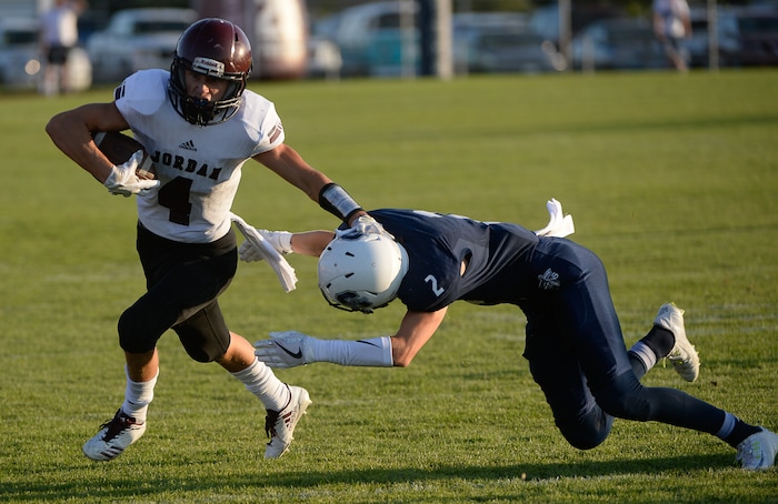 (Francisco Kjolseth  |  The Salt Lake Tribune)  Jordan's Ethan Bolingbrooke manages to hold off a tackle by Kaden Mueller of Syracuse in game action at Syracuse on Thursday, Aug. 24, 2017.