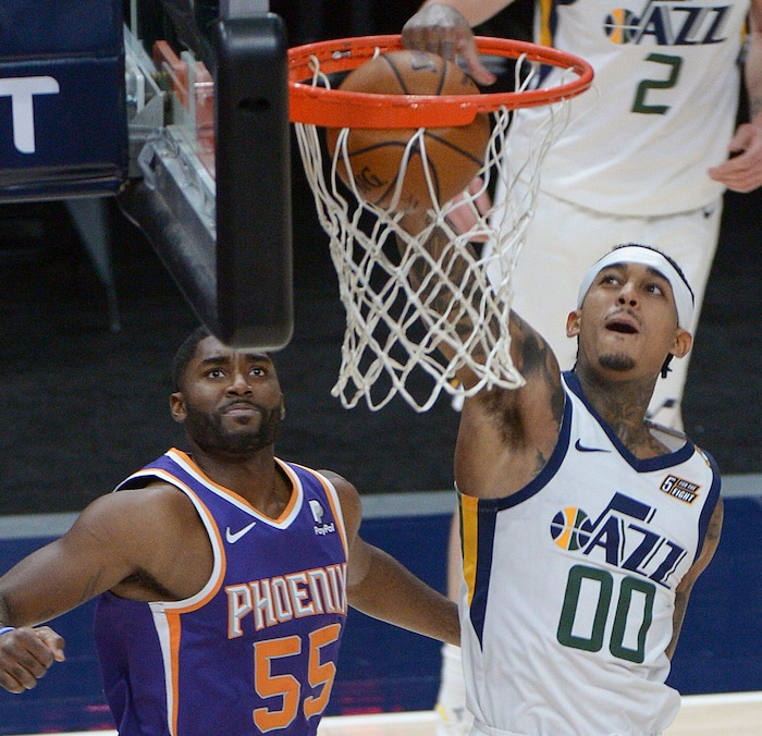 (Leah Hogsten | The Salt Lake Tribune) Utah Jazz guard Jordan Clarkson (00) stuffs the net as Phoenix Suns guard E'Twaun Moore (55) watches as the Jazz crack open their 2020-21 preseason with their second game against the Phoenix Suns, Dec. 14, 2020.