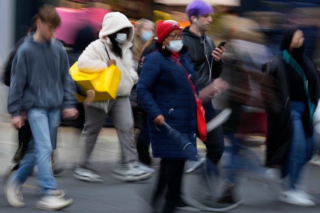 (Frank Augstein | AP) Shoppers walk along Oxford Street, Europe's busiest shopping street, in London, Dec. 15, 2021. The new omicron variant speeding around the world may bring another wave of chaos, threatening to further stretch hospital workers already struggling with a surge of delta cases and upend holiday plans for the second year in a row.