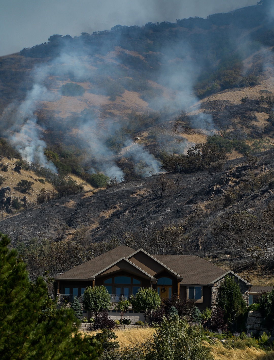 (Francisco Kjolseth  |  The Salt Lake Tribune)  The mountain side burs near homes as crews battle the blaze along the East Bountiful bench that grew to 150 acres early Friday morning, Aug. 30, 2019, and destroyed three homes.  On Sept. 2, officials said the fire was 100% contained.