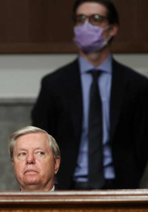 (Jonathan Ernst | AP) Senate Judiciary Committee Chairman Lindsey Graham, R-S.C., presides over Judge Justin Walker's confirmation hearing on his nomination to be a U.S. Circuit Court judge for the District of Columbia Circuit as a committee staff member stands behind him wearing a protective face mask, on Capitol Hill in Washington, Wednesday, May 6, 2020.