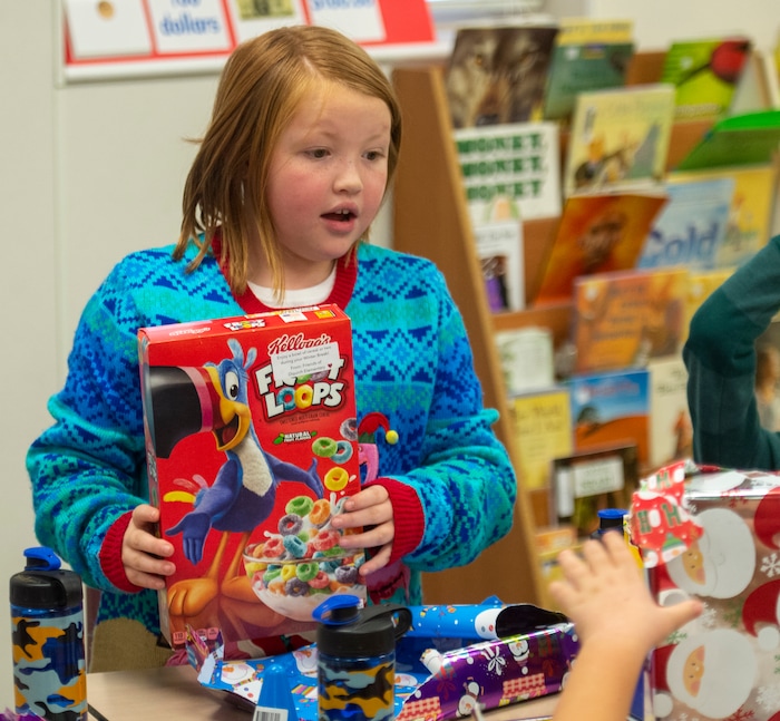 (Rick Egan  |  The Salt Lake Tribune)   Madi Clauder, third grade student, holds up her his box of cereal. Ms. Worthington the principal, surprised all 650 students at her school with the gift-wrapped boxes of cereal, at Oquirrh Elementary in West Jordan, Thursday, Dec. 20, 2018.


