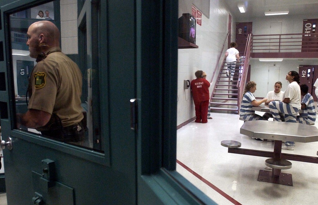 (Leah Hogsten |  Tribune file photo) This file photo of the Davis County Jail in Farmington was taken Dec. 18, 2002. Above, Deputy Joey Clark exits Pod H, one of two pods for women that are filled to capacity.
