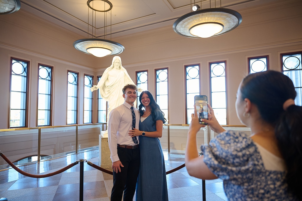 (The Church of Jesus Christ of Latter-day Saints) Conferencegoers admire a statue of Jesus in the Conference Center during April's General Confeerence. Since its founding, the church has faced arguments that the religion isn't as Christian as its adherents claim.