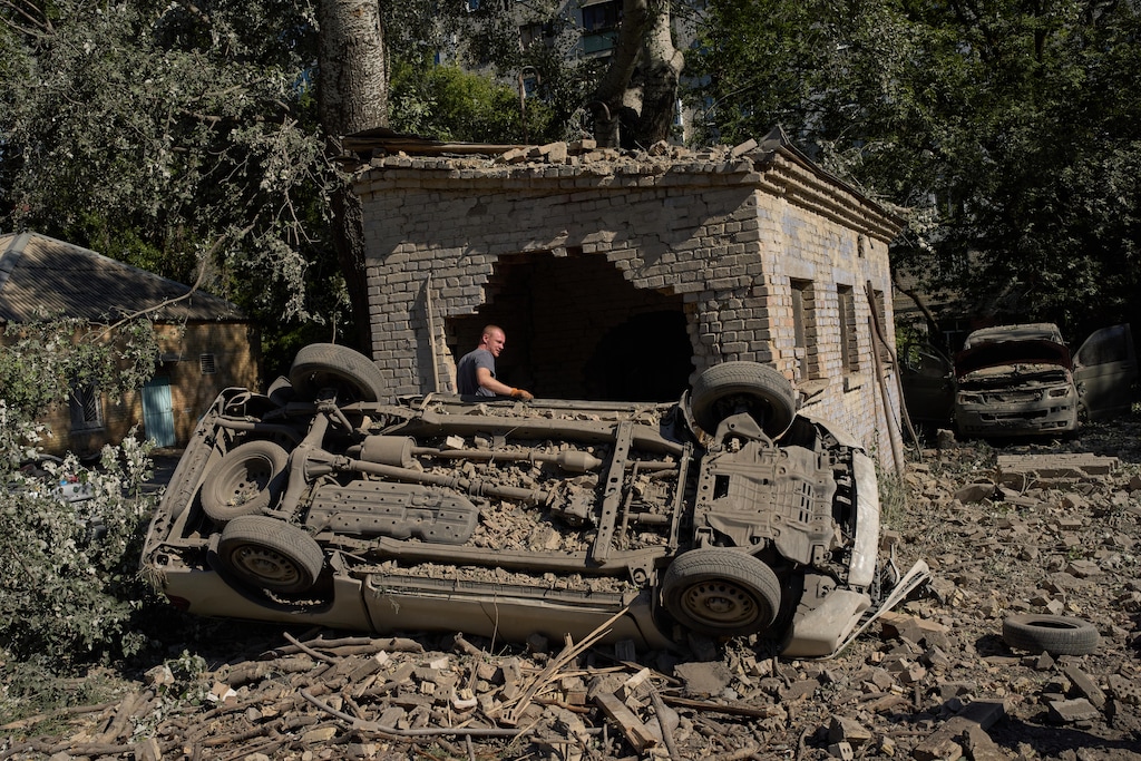 A local resident stands next to destroyed cars after an overnight Russian missiles and drones attack, in Kyiv, Ukraine, Thursday, Aug. 20, 2026 (AP Photo/Francisco Seco) UKRAINE (Press Association via AP Images)
