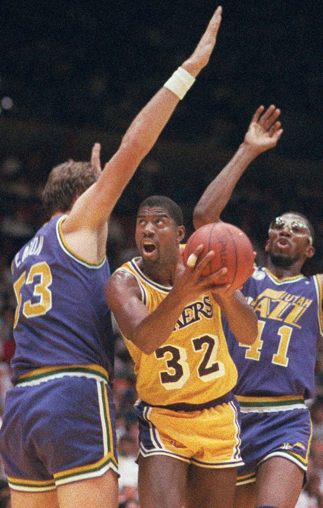 Los Angeles Lakers' Magic Johnson (32) muscles his way between Mark Eaton, left, and Thurl Bailey of the Utah Jazz in Inglewood, Calif., on May 8, 1988.   (AP Photo/Mark Terrill)