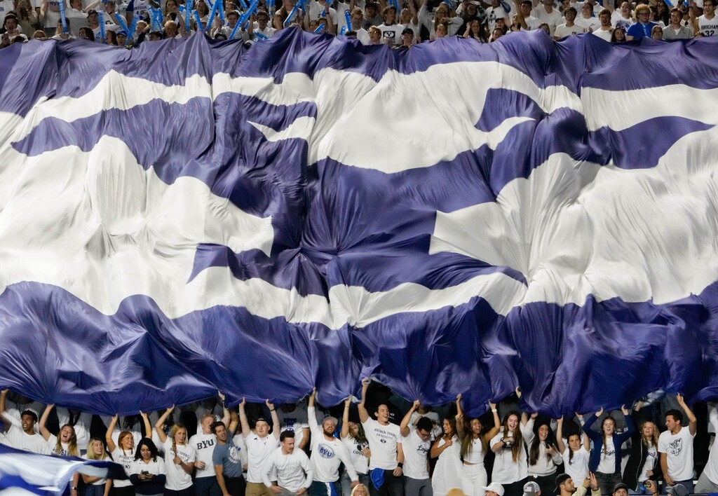 (Francisco Kjolseth | The Salt Lake Tribune) Brigham Young Cougar fans shake the school flag as they cheer on the Cougars against the Arizona State Sun Devils at LaVell Edwards Stadium in Provo, on Saturday, Sept. 18, 2021.