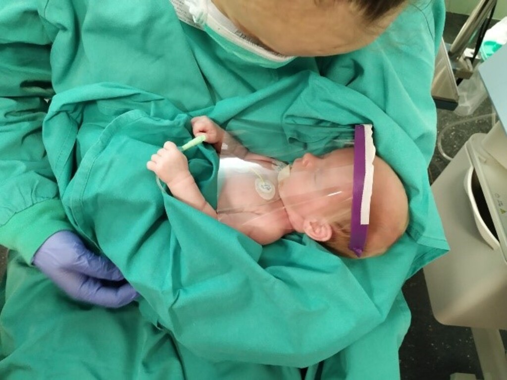 (Photo courtesy of The Church of Jesus Christ of Latter-day Saints)
Health care worker and premature infant with protective visor manufactured by a 3D printer, paid for by Latter-day Saint Charities.