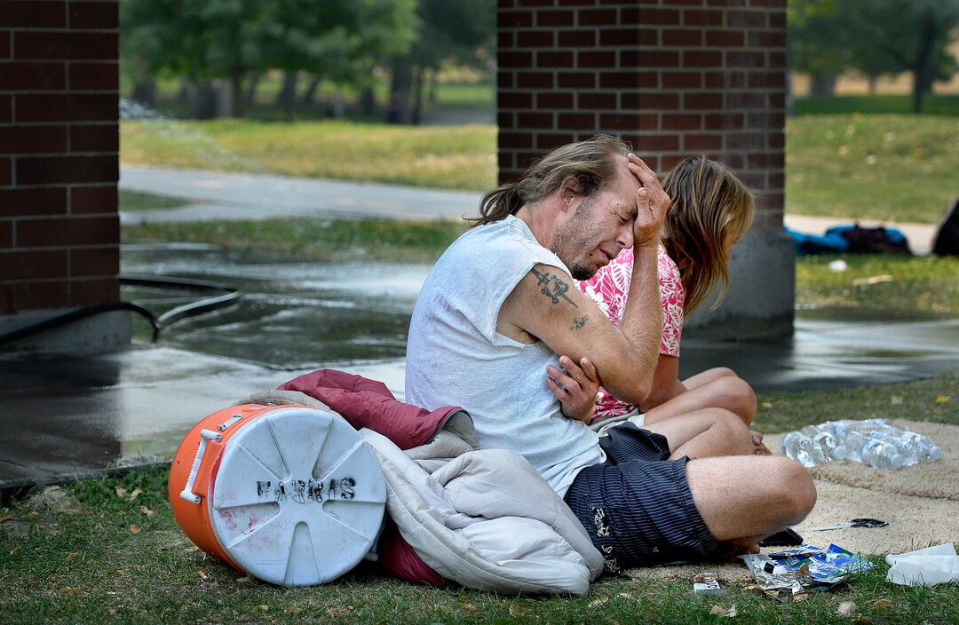 (Scott Sommerdorf   |  The Salt Lake Tribune)   Homeless couple Daniel White and Angela Nuhl sit together in Fairmont Park after getting some bottled water from Volunteers of America workers who were in the park checking on campers, Wednesday, September 6, 2017.