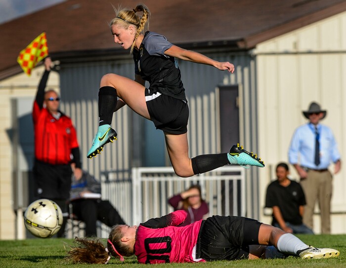 (Steve Griffin  |  The Salt Lake Tribune)  Davis forward Sami Bates leaps over Copper Hills goal keeper McCaslin Davis during the Class 6A girls' soccer playoff game at Copper Hills High School in West Jordan Tuesday October 10, 2017.