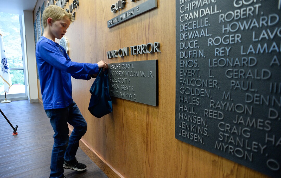 (Francisco Kjolseth  |  The Salt Lake Tribune)  Jacob Taylor, 8, decides to keep all the bits and pieces of the small curtain that covered his late father's name, Major Brent Taylor now added to the Wilkinson Student Center Reflection RoomÕs Memorial Wall at Brigham Young University on Thursday, May 23, 2019. The former mayor of North Ogden and a BYU Army ROTC alumnus who was killed in Afghanistan in 2018, was honored by the BYU Army ROTC who added his name to the list of 211 who have died in service.