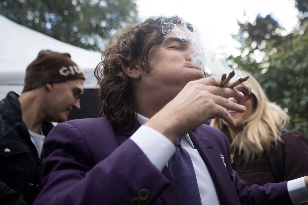 FILE - In this Oct. 17, 2018, file photo, a man smokes multiple joints in a Toronto park as they mark the first day of legalization of cannabis across Canada. Supply shortages have been rampant in the two weeks since Canada became the largest national pot marketplace. (Chris Young/The Canadian Press via AP, File)