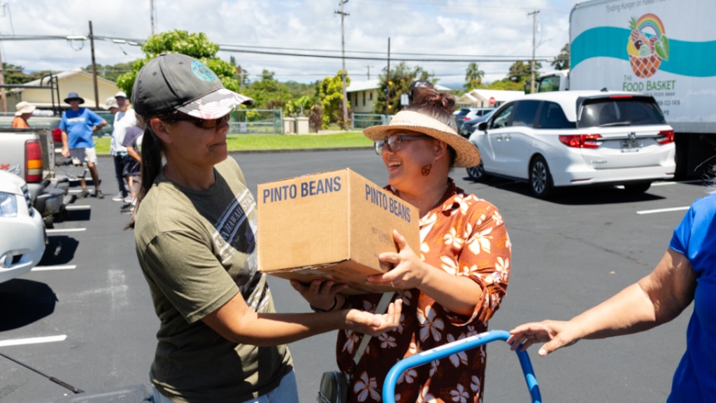 (The Church of Jesus Christ of Latter-day Saints) At a church meetinghouse parking lot in Hilo, Hawaii, on June 13, 2026, nonprofit representatives, members and friends of The Church of Jesus Christ of Latter-day Saints meet to organize a food donation from the church as part of the America250 America Gives Initiative. Hawaii is the 50th state to receive a church donation.