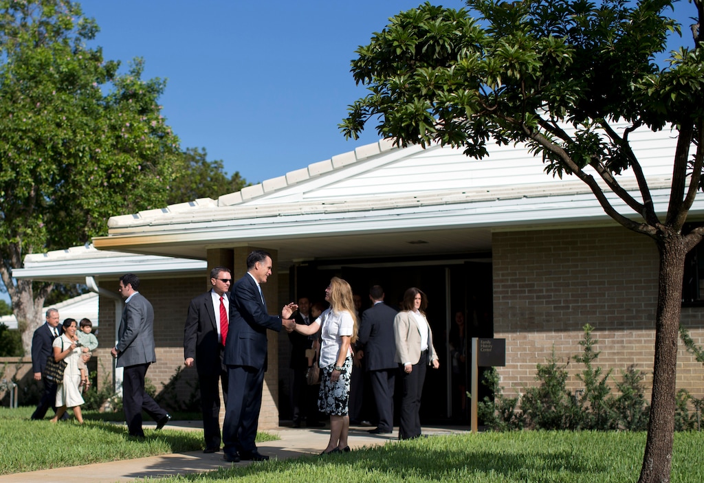 (Evan Vucci | AP) Then-presidential candidate Mitt Romney talks with congregants as he leaves a Latter-day Saint meetinghouse after service on Sunday, Oct. 21, 2012, in Boca Raton, Fla.