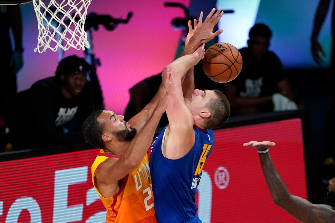 Denver Nuggets' Nikola Jokic (15) is fouled by Utah Jazz's Rudy Gobert during the second half of an NBA basketball first round playoff game Sunday, Aug. 30, 2020, in Lake Buena Vista, Fla. (AP Photo/Ashley Landis)