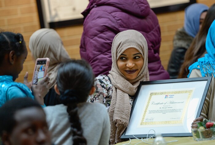 (Francisco Kjolseth  |  The Salt Lake Tribune)  Masagid Abdalla a refugee from Sudan has her picture taken with her new award of achievement during the Women of the World 8th annual award ceremony at the Salt Lake County building in Salt Lake City on Saturday, Dec. 8, 2018. The event is a celebration of successes including educational, service, and employment milestones by refugee women.