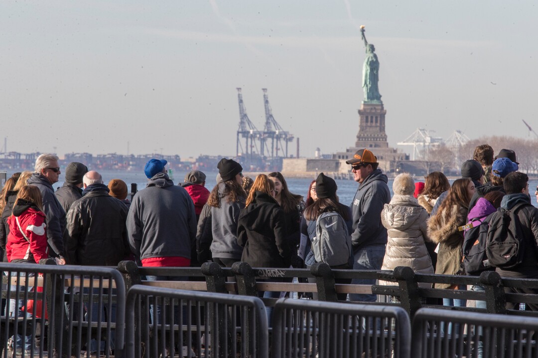 Visitors to the Statue of Liberty stand in line to board a ferry that will cruise the bay around the statue and Ellis Island, Saturday, Jan. 20, 2018, in New York. The National Park Service announced that the Statue of Liberty and Ellis Island would be closed Saturday "due to a lapse in appropriations." Late Friday, the Senate failed to approve legislation to keep the government from shutting down after the midnight deadline. (AP Photo/Mary Altaffer)