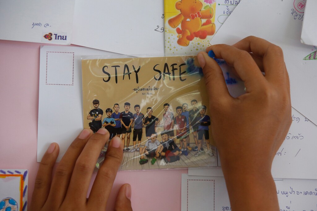 (AP Photo/Sakchai Lalit) A Thai well wisher puts a poster to pray for boys and their soccer coach who have been trapped since June 23, in Mae Sai, Chiang Rai province, northern Thailand Monday, July 9, 2018. Expert divers Sunday rescued four of 12 boys from a flooded cave in northern Thailand, as a dangerous and complicated operation unfolded amid heavy rain and the threat of rising water underground.