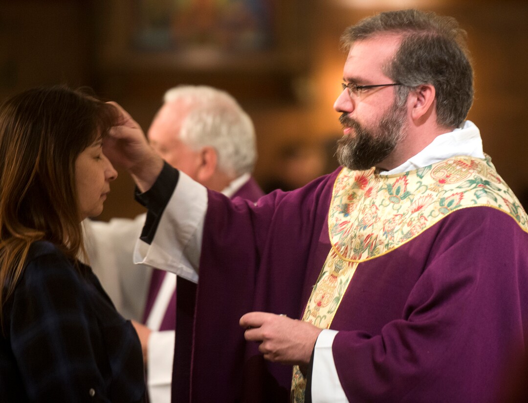 (Rick Egan  |  The Salt Lake Tribune)   The Reverend Christopher P. Gray, dispenses ashes, on the forehead of Brenda Gonzales, during the Ash Wednesday Mass, at the Cathedral of The Madeleine, Wednesday, Feb. 14, 2018.