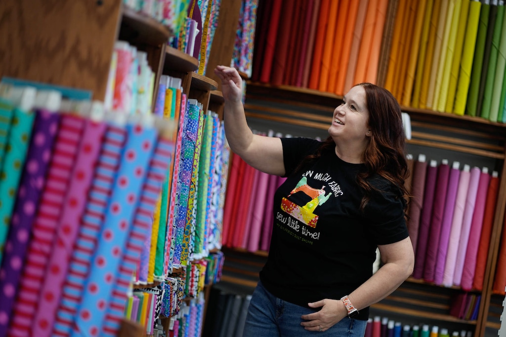 (Francisco Kjolseth | The Salt Lake Tribune) Whitney Warner, store manager at My Girlfriend’s Quilt Shoppe in Sandy, overlooks the fabric selections, Wednesday, Oct. 12, 2022.