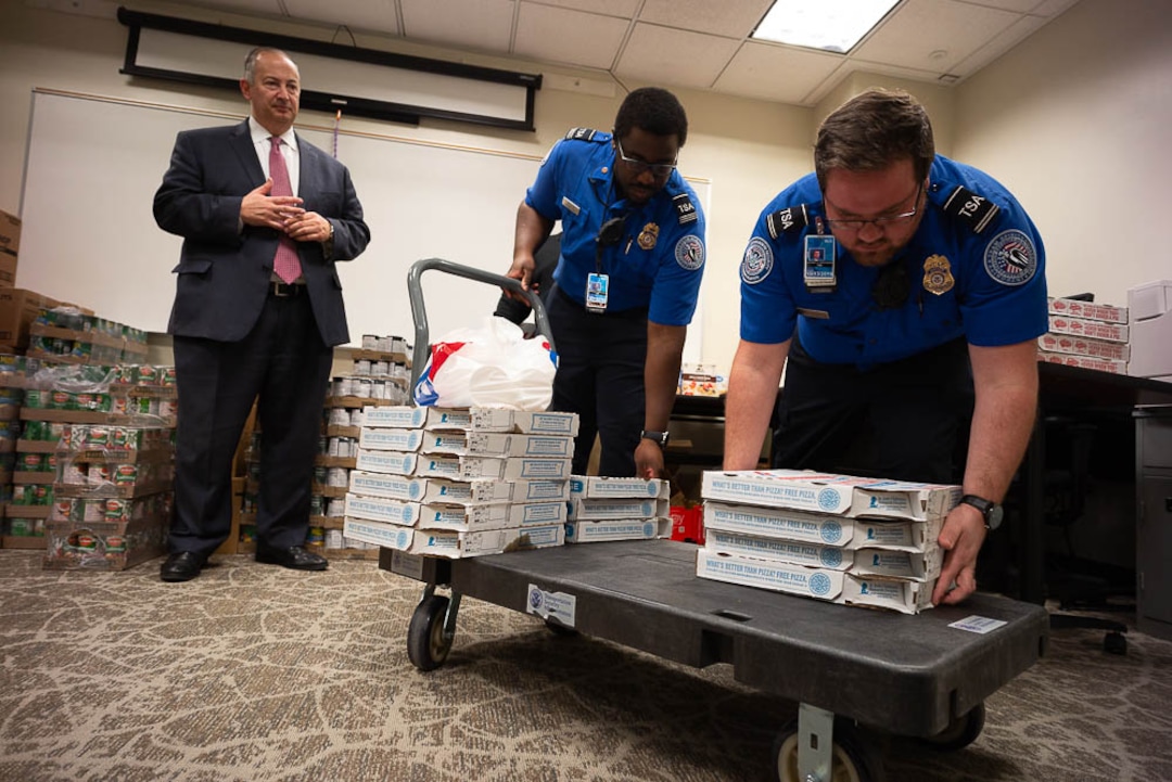 (Trent Nelson | The Salt Lake Tribune)  Salt Lake City Mayor Jackie Biskupski had pizza delivered to TSA and other federal employees to thank them for working at the airport without pay during the partial federal shutdown on Tuesday Jan. 22, 2019. Food from the Utah Food Pantry was stacked around the training room to cover the needs of employees.  From left are Mark Lewis, Marcus Smauldon, and Anthony Christensen.