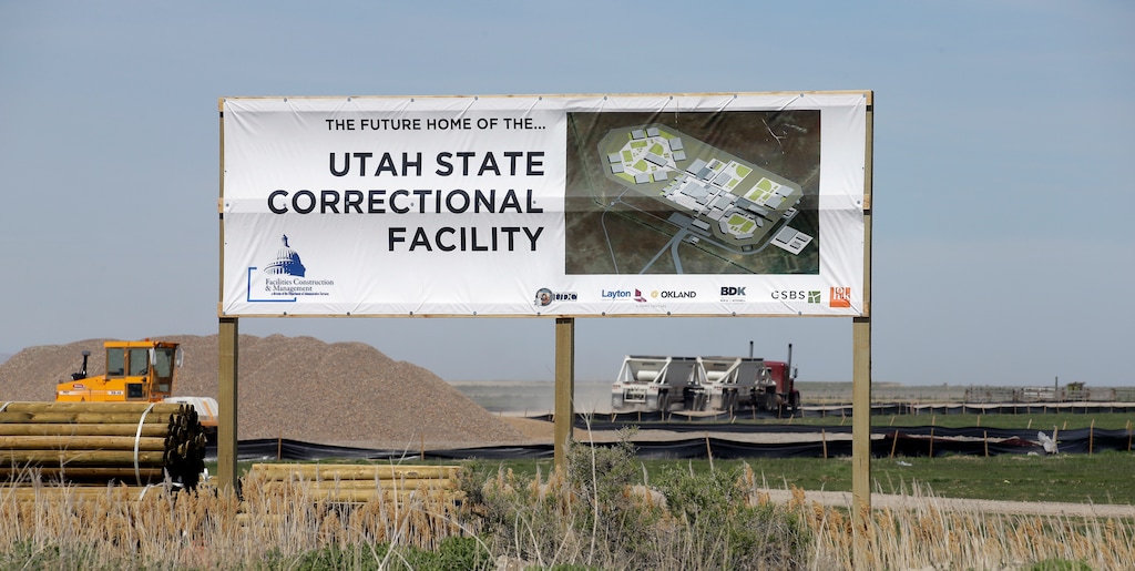 In this April 6, 2017, photo, a sign showing the future site of the Utah State Correctional Facility is displayed near the Salt Lake City International Airport. State officials say the new state prison is expected to be completed by the end of 2020 as scheduled, but that inmates won't be moved there until the next year. Officials said Friday, April 14, 2017, during a Prison Development Commission hearing that it will take about six months to transition prisoners from the current facility in Draper to the new one about 25 miles north near the Salt Lake City International Airport. (AP Photo/Rick Bowmer)