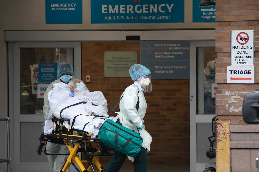 A patient is moved by healthcare workers at Maimonides Medical Center, Wednesday, May 6, 2020, in New York during the coronavirus pandemic. The great majority of people newly hospitalized with the coronavirus in New York are either retired or unemployed and were avoiding public transit, according to a new state survey, the first such look at people still getting seriously ill despite six weeks of severe social distancing. (AP Photo/Mark Lennihan)