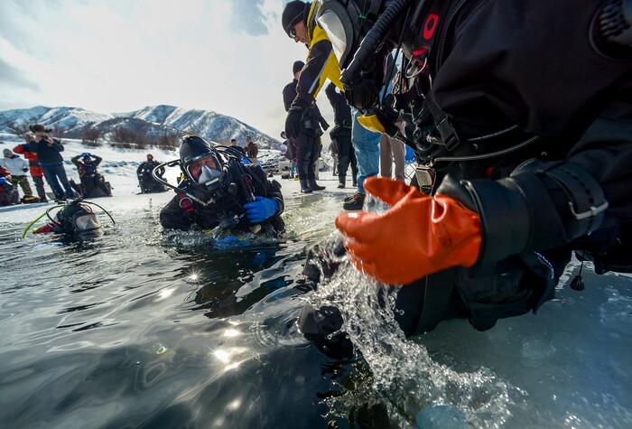 Leah Hogsten | The Salt Lake Tribune l-r Utah Department of Public Safety's Dive Team members Jeff Arbon, Adam Walker and Don Gould enter the water for training. The Utah Department of Public Safety's Dive Team and the Riverside County Sheriff's Office joined forces for a day of ice diving at Deer Creek Reservoir, Feb. 20, 2019. Twenty members from Riverside County Sheriff's Department dove in icy waters alongside DPS' 10 man team in a joint team training day, Wednesday. Members of the Riverside County Sheriff's were working to become certified in ice diving under the team's lieutenant and dive master. Due to the equipment assets and the unique diver skill sets, dive teams are often called upon to provide assistance to aquatic homicide investigations and accidental drownings.