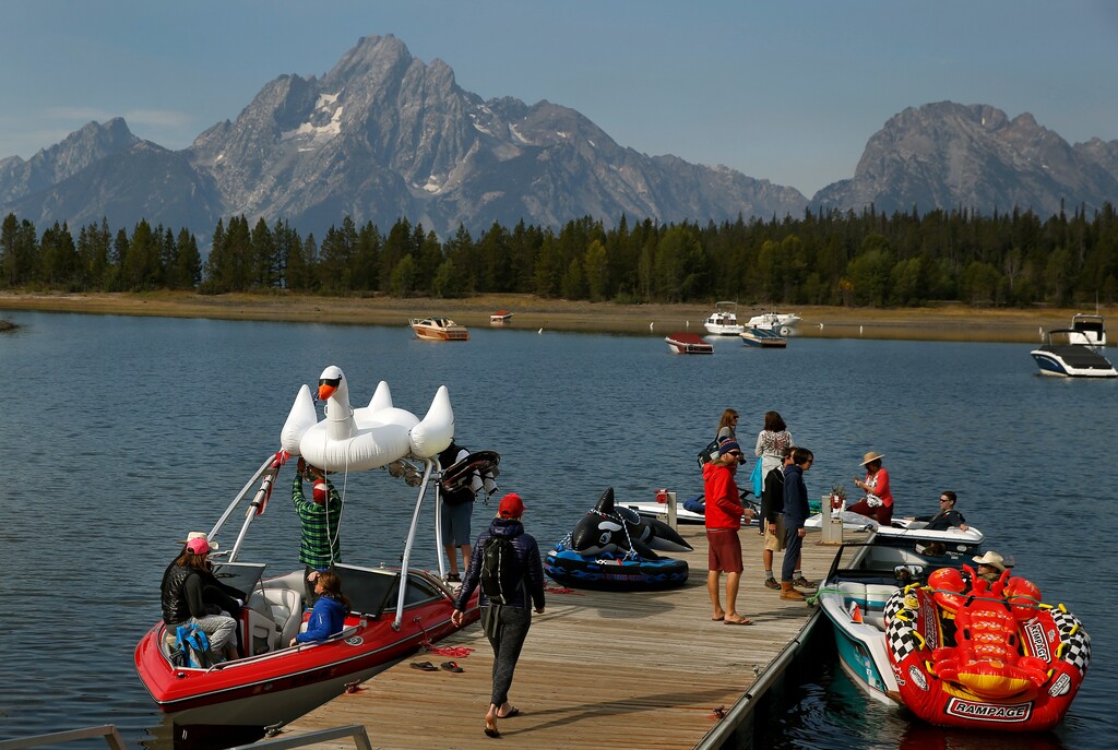 (Brennan Linsley | The Associated Press) In this Aug. 27, 2016 file photo, members of a wedding party prepare to depart for a marriage ceremony on boats on Jackson Lake, at Coulter Bay, in Grand Teton National Park, Wyo. The National Park Service is floating a proposal to increase entrance fees at 17 of its most popular sites next year.