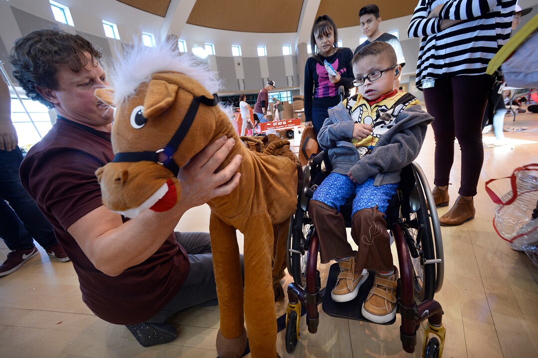 (Scott Sommerdorf   |  The Salt Lake Tribune)   Luis Angel Flores, 5 years old, is introduced to the horse that will be attached to his wheelchair by volunteer Scott Jerome. Shriners Hospitals for Children volunteers  transformed the wheelchairs of 20 patients for Halloween, Wednesday, October 18, 2017. 