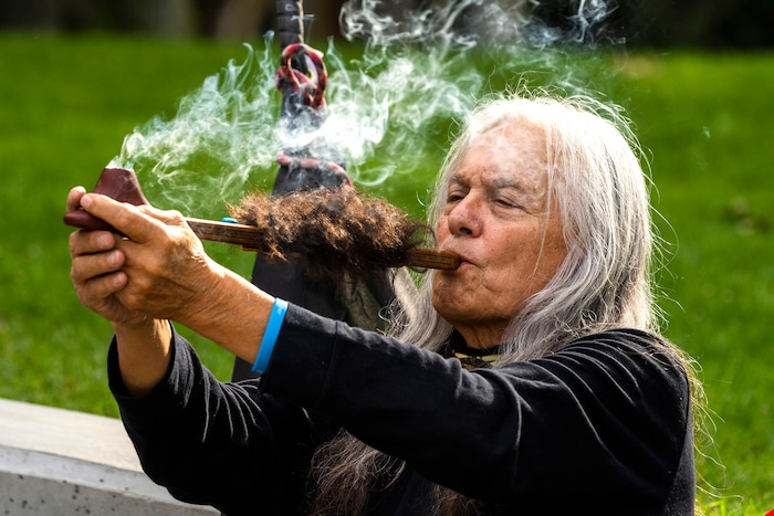 (Rick Egan | The Salt Lake Tribune) Warren Flamingeagle Mooney
Smokes a prayer pipe, at Murray Park for a prayer vigil in honor of UtahÕs Afghan refugees, onSaturday, Aug. 21, 2021.