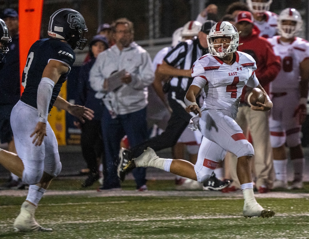 (Rick Egan | The Salt Lake Tribune) East High Quarterback Siona Vailahi (4) out runs Harrison Taggart (9), in prep football action between Corner Canyon Chargers and the East Leopards, on Saturday, Aug. 21, 2021.