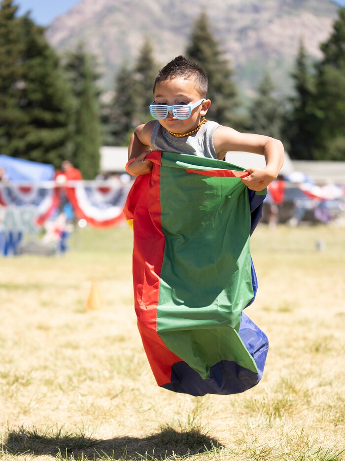 (Rick Egan | The Salt Lake Tribune)  Dante Delgado participates in the sack race, during the Cherry Days Fourth of July celebration, in North Ogden, on Monday, July 4, 2022.