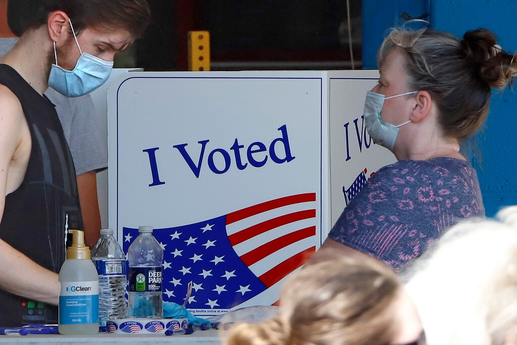 (Gene J. Puskar | The Associated Press)
A voter fills out his ballot as a woman waits her turn during primary voting at the public safety building in McKeesport, Pa., Tuesday, June 2, 2020.