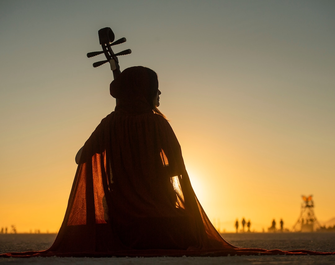 (Rick Egan  |  The Salt Lake Tribune)   Elena Wang, Beijing China, plays an ancient Chinese instrument called a "Pipa" as the sun rises, at Burning Man, in the Black Rock Desert, near Gerlach, Nevada. Saturday, Aug. 31, 2019.