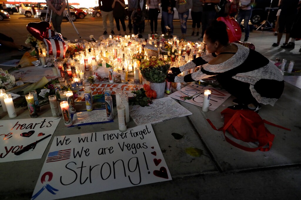 A woman places a candle at a memorial for victims of the mass shooting Tuesday, Oct. 3, 2017, in Las Vegas. A gunman opened fire on an outdoor music concert on Sunday. It was the deadliest mass shooting in modern U.S. history, with dozens killed and hundreds injured, some by gunfire, some during the chaotic escape. (AP Photo/Marcio Jose Sanchez)