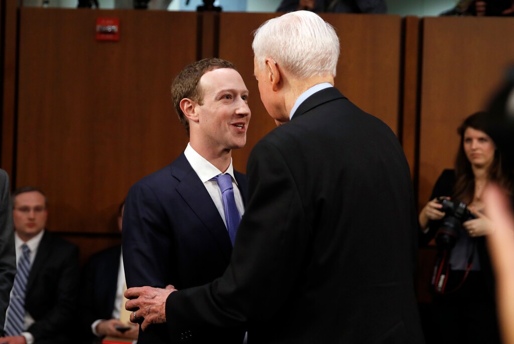 Facebook CEO Mark Zuckerberg, left, is greeted by Sen. Orrin Hatch, R-Utah, before returning to his seat to continue testifying before a joint hearing of the Commerce and Judiciary Committees on Capitol Hill in Washington, Tuesday, April 10, 2018, about the use of Facebook data to target American voters in the 2016 election. (AP Photo/Alex Brandon)