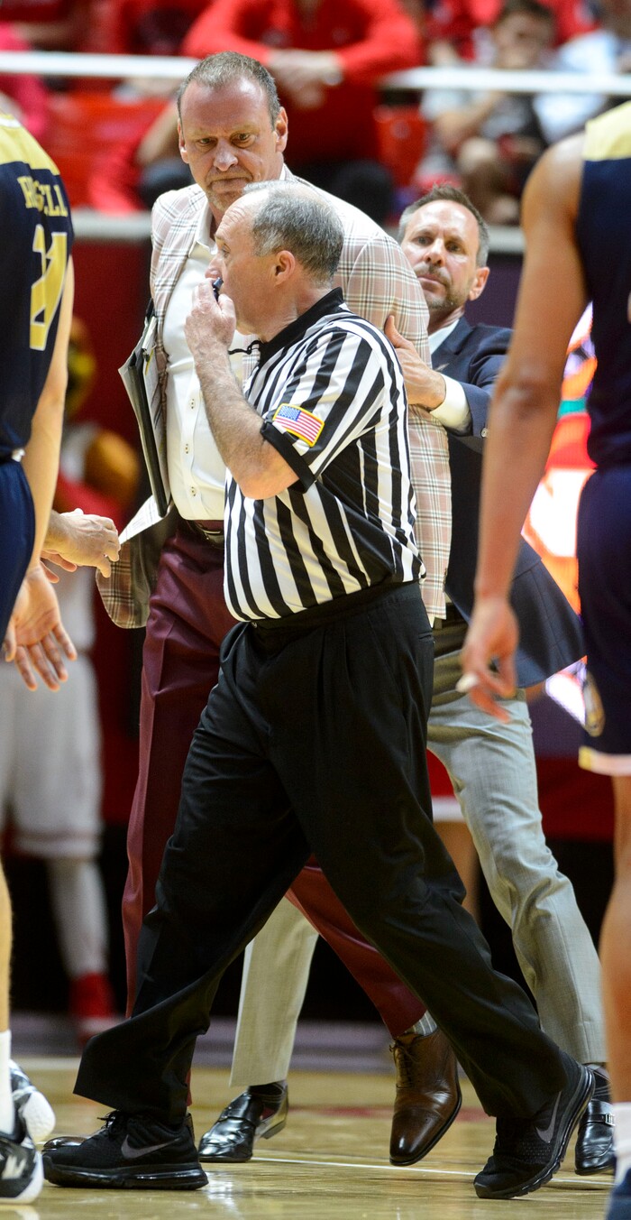 (Steve Griffin  |  The Salt Lake Tribune) University of Utah head coach  Larry Krystkowiak is held back by assistant  after he stormed onto the court after a foul was called on his team during the Utah versus UC Davis men's NIT basketball game at the Huntsman Center in Salt Lake City Wednesday March 14, 2018. Krystkowiak was ejected from the game.
