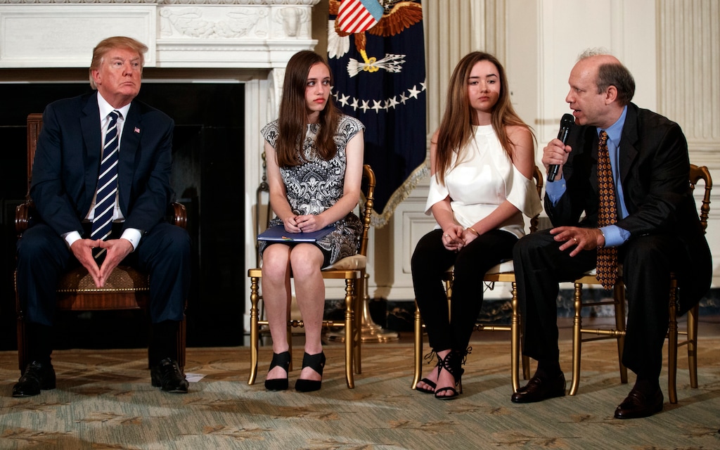 From left, President Donald Trump, Marjory Stoneman Douglas High School student students Carson Abt, and Ariana Klein, listen as Carson's father Frederick Abt, speaks during a listening session with high school students, teachers, and others in the State Dining Room of the White House in Washington, Wednesday, Feb. 21, 2018. In the aftermath of yet another mass school shooting, Trump says that if one of the victims, a football coach, had been armed “he would have shot and that would have been the end of it.” Revisiting an idea he raised in his campaign, Trump’s comments in favor of allowing teachers to be armed come as lawmakers in several states are wrestling with the idea, including in Florida, where the 17 most recent school shooting victims are being mourned.(AP Photo/Carolyn Kaster)