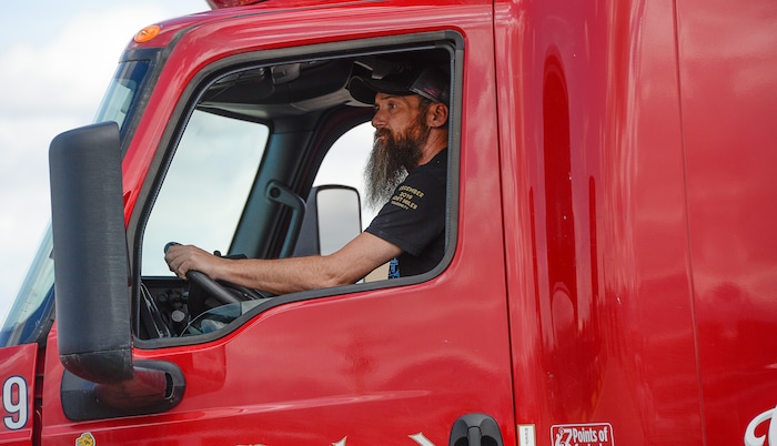 (Francisco Kjolseth | The Salt Lake Tribune) Trucks come and go at C.R. England trucking in Salt Lake City on Monday, March 30, 2020. The coronavirus outbreak has helped make truckers heroes as they help to stock empty shelves in stores. Drivers face new challenges from finding restrooms and food on the road amid shutdowns, but say they enjoy driving with no congestion.