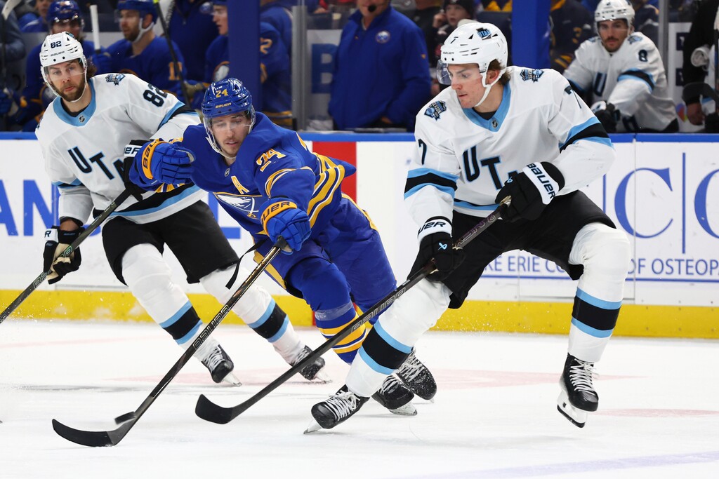 Buffalo Sabres center Dylan Cozens (24) and Utah defenseman Michael Kesselring (7) race for the puck during the first period of an NHL hockey game Saturday, Dec. 7, 2024, in Buffalo, N.Y. (AP Photo/Jeffrey T. Barnes)