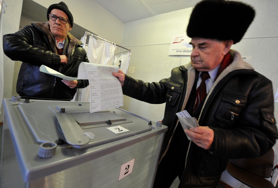 Two men cast their ballots at a polling station in Yelizovo, about 30 kilometers ( 19 miles) north-east from Petropavlovsk-Kamchatsky, capital of Kamchatka Peninsula region, Russian Far East, Russia, on Sunday, March. 18, 2018. Polls have opened in Russia's Far East for the presidential election in which Vladimir Putin seeks a 4th term. (AP Photo/Alexander Petpov)
