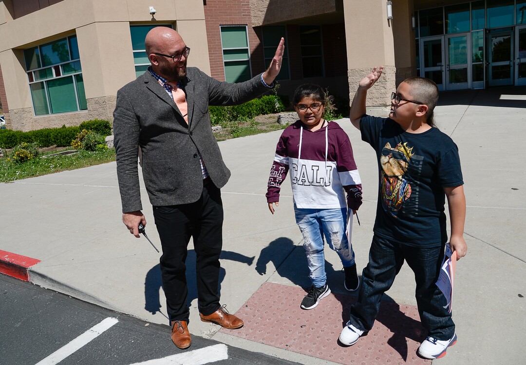 (Francisco Kjolseth  |  The Salt Lake Tribune)  Washington Elementary school principal John Kelly, gets a high five from siblings Marisol and Victor Perez following their first day back at school on Monday, Aug. 19, 2019.