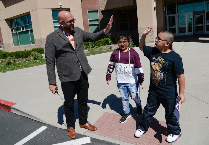 (Francisco Kjolseth | The Salt Lake Tribune) Washington Elementary school principal John Kelly, gets a high five from siblings Marisol and Victor Perez following their first day back at school on Monday, Aug. 19, 2019.