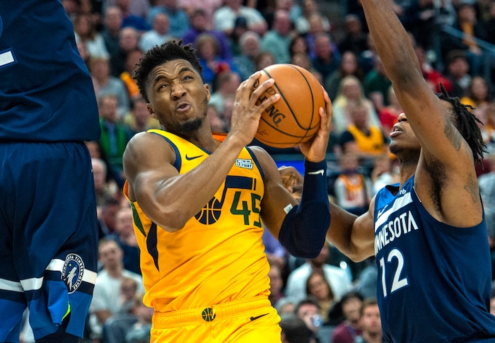 (Rick Egan  |  The Salt Lake Tribune)     Utah Jazz guard Donovan Mitchell (45) takes the ball inside as he slides between Minnesota Timberwolves center Karl-Anthony Towns (32) and Minnesota Timberwolves guard Treveon Graham (12), in NBA action between the Utah Jazz and the Minnesota Timberwolves in Salt Lake City, Monday, Nov. 18, 2019.