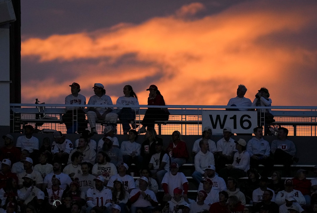 (Bethany Baker  |  The Salt Lake Tribune) Light from the sunset illuminates the sky as fans watch during the game between the Utah Utes and the Kansas Jayhawks at Rice-Eccles Stadium in Salt Lake City on Saturday, Oct. 10, 2026.