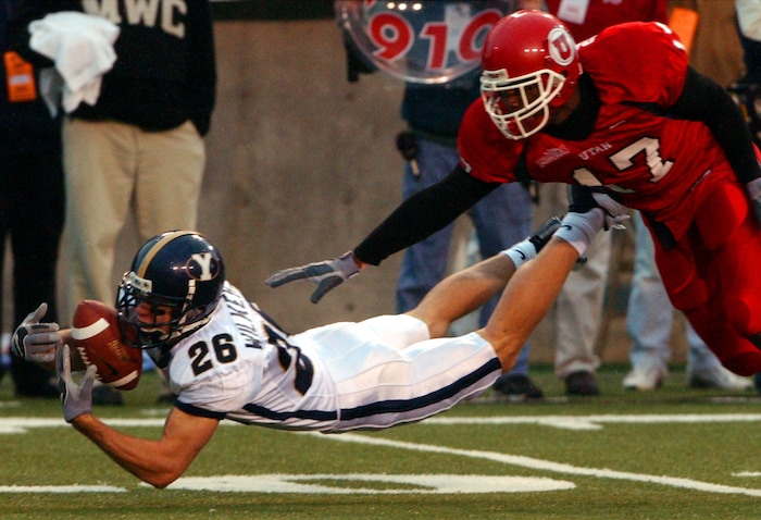 (Tribune File Photo)  BYU's #26 Rodney Wilkerson makes the dive but can't keep a handle on the ball as Utah #17 Arnold Parker defends during the rivalry game on November 23, 2002. 