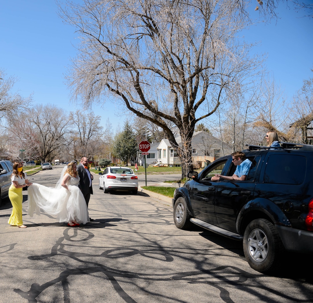 (Trent Nelson  |  The Salt Lake Tribune) Newlyweds Kadie and Tyler van Roosendaal cross the street to greet friends and family who watched the wedding from their vehicle, in Salt Lake City on Saturday, April 4, 2020.