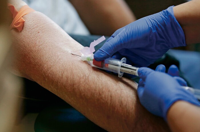 (Luis Sánchez Saturno | Santa Fe New Mexican | The Associated Press) In this Wednesday, April 25, 2018 photo, Andrea Rodriguez, clinical research coordinator, draws blood from Patrick Coss at Southwest Care in Santa Fe, N.M. The HIV/AIDS clinic has been at the forefront of AIDS research over the past 30 years.